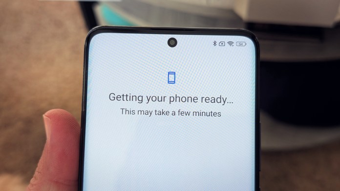 Close-up of a smartphone screen displaying a setup message that reads 'Getting your phone ready... This may take a few minutes' with connection icons in the status bar.