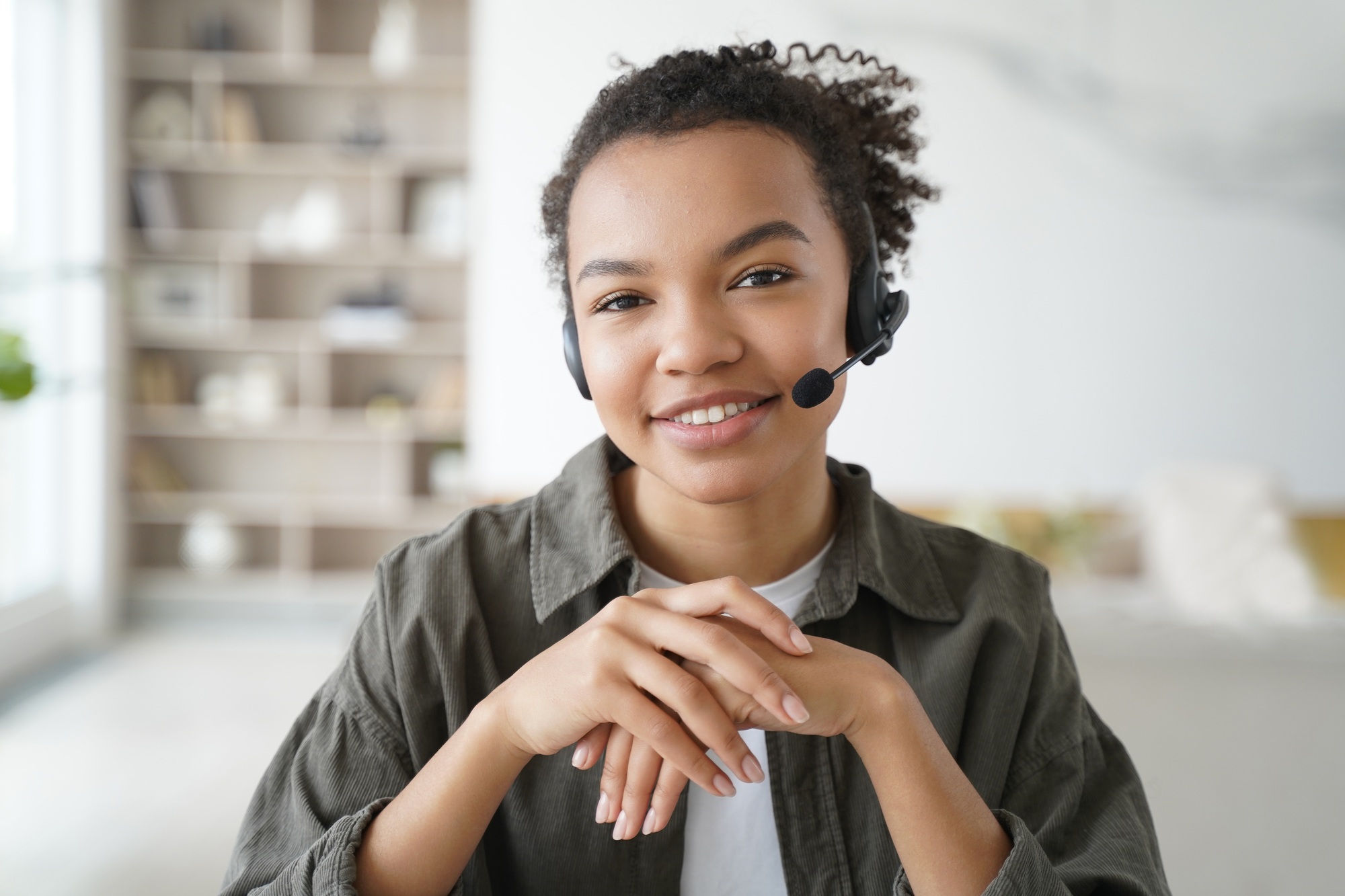 Virtual assistant. Young afro woman in headset is operator of client support service from home.