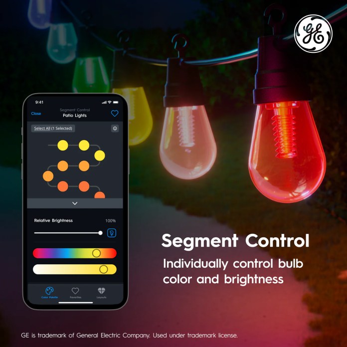 A smartphone displaying a color control interface for Cync Dynamic Effects Smart Café Lights, showing options for individual bulb color and brightness adjustment, with colorful lights hanging in the background.