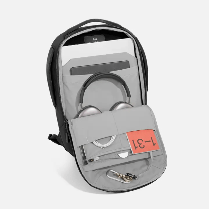 An open backpack showcasing its interior compartments, including space for headphones and a laptop, designed for organization and ease of access.