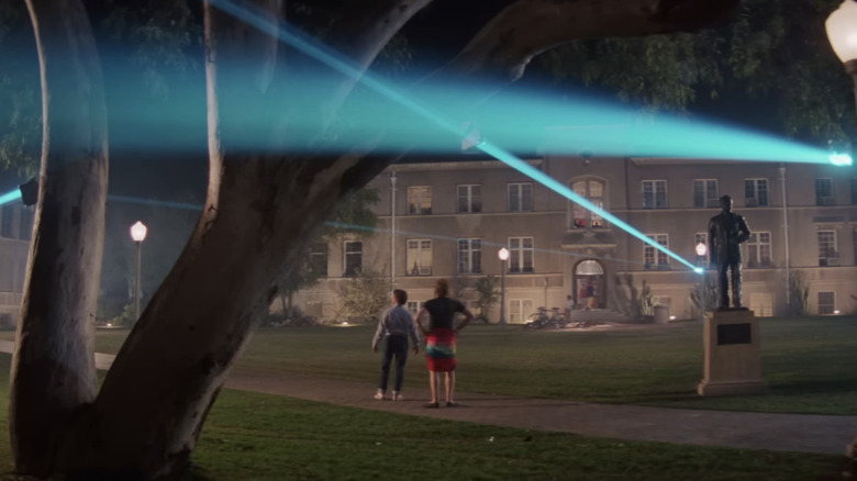 Val Kilmer's Chris Knight stands in a courtyard admiring his laser technology in Real Genius