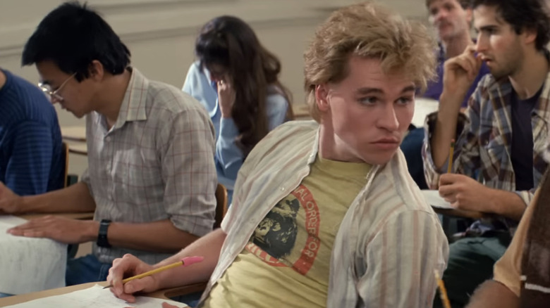 Val Kilmer's Chris Knight leans to his left as he sits in a lecture theater in Real Genius